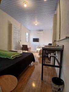 a bedroom with a bed and a desk in a room at Hotel New in Alegrete