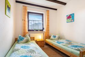 two beds in a small room with a window at Ferienwohnung Spatzennest in Arrach