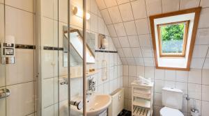 a bathroom with a sink and a toilet and a window at Captain Pahlen Ferienanlage in Zingst +220 photos