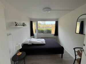 a small bedroom with a bed and a window at Slottets Anneks in Rønne