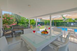 a table with a bowl of fruit and wine glasses at Villa Ata Park Ortaca in Ortaca