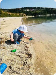 a young child playing in the sand on the beach at Studio Sanja in Vlašići +1 photo