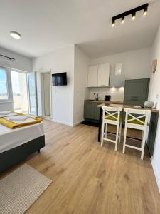 a living room with a bed and a kitchen at Studio Sanja in Vlašići