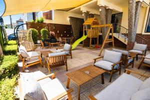 a patio with chairs and a playground with a slide at Hotel M2 in Primorsko