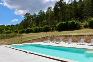 a swimming pool with lounge chairs and a swimming pool at Moulin Haut in Rouffignac Saint-Cernin