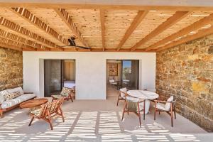 an outdoor patio with a brick wall and wooden ceiling at Fouquet's Mykonos in Mikonos