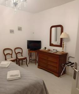 a bedroom with a bed and a dresser with a mirror at Entre Brionnais Et Bourbonnais in Montaigüet-en-Forez