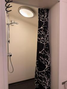 a shower in a bathroom with a black and white curtain at Bondasgården in Lima +45 photos