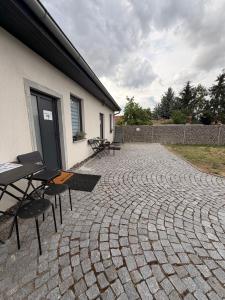 a patio with chairs and a table and a building at Apartmány KK in Chvalovice