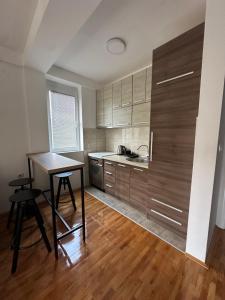 a kitchen with wooden cabinets and a table and chairs at Zen Apartment in Kumanovo
