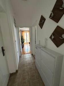 a kitchen with white cabinets and a tile floor at Zen Apartment in Kumanovo +3 photos