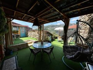 a patio with a table and chairs and an umbrella at Rincón del Viso in Ourense