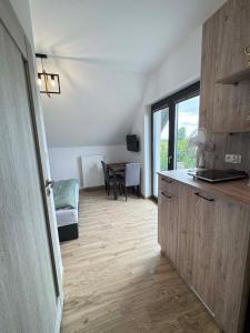 a room with a kitchen with a table and a counter at Rajska Zatoka Jantar in Jantar