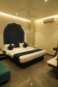 a bedroom with a large bed with a black headboard at Hotel Orbit in Parbhani