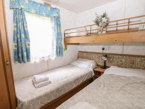 two beds in a small room with a window at 10 Cater Gardens in Guildford