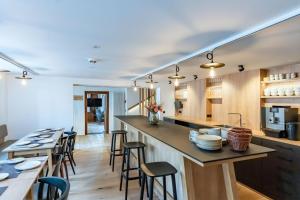 a kitchen with wooden cabinets and a bar with stools at Münsterhus Josefs Alpine Lodge in Schruns