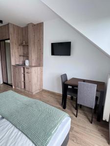 a bedroom with a bed and a table and a tv at Rajska Zatoka Jantar in Jantar