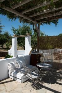 a patio with a couch and a table and chairs at Visinokipos House in Mirsíni