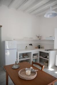 a dining room with a table and a kitchen at Visinokipos House in Mirsíni