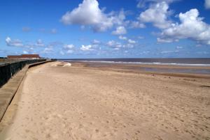 a sandy beach with a pier and the ocean at Ingoldmells holiday in Ingoldmells