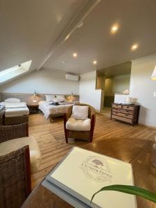 a large room with a bed and a couch and a table at A la terre ferme in Arnac-la-Poste