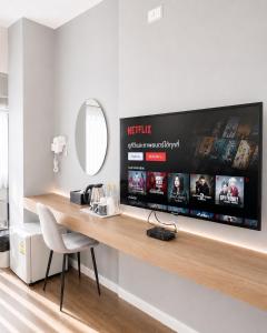 a room with a desk with a tv on a wall at The S Design Hotel in Buriram +11 photos