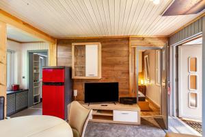 a living room with a red refrigerator and a tv at Ferienhaus 203 in Zadelsdorf