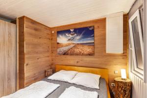 a bedroom with a bed in a room with wooden walls at Ferienhaus 203 in Zadelsdorf
