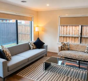 a living room with a couch and a glass table at Modern Family Home in Truganina - Space to Relax in Truganina