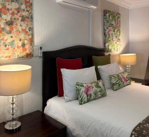 a bedroom with a bed with pillows and two lamps at Tsheryl's Residence in Centurion +20 photos
