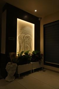 a large painting on the wall in a room with plants at Hotel Orbit in Parbhani