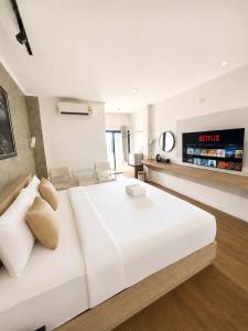 a large white bed in a room with a television at The S Design Hotel in Buriram