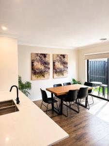 a kitchen and dining room with a table and chairs at Modern Family Home in Truganina - Space to Relax in Truganina +12 photos