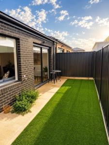 a backyard with green grass and a fence at Modern Family Home in Truganina - Space to Relax in Truganina
