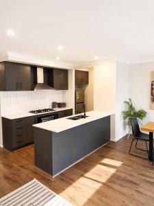 a kitchen with a large island in the middle at Modern Family Home in Truganina - Space to Relax in Truganina