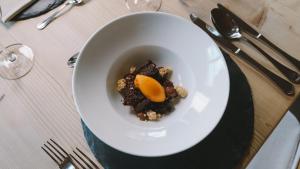 a white bowl of food on a table at Hotel Innerhofer in Gais