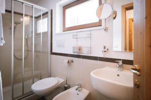 a bathroom with a sink and a toilet and a shower at Hotel Innerhofer in Gais +30 photos