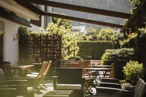 a patio with tables and chairs and a fence at Hotel Innerhofer in Gais