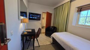a hotel room with a bed and a desk and a window at Norrqvarn Hotel & Resort by Vänerport in Lyrestad