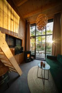 a living room with a couch and a chandelier at Tiny House of Happiness - shared hot tub in Otterlo