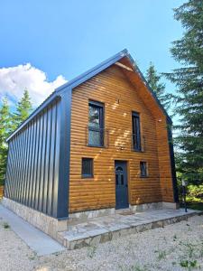 a small wooden house with a black door at Villa Jelterra in Uskoci