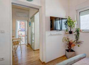 a living room with a tv on a wall at Apartment Matoš in Omiš