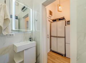 a white bathroom with a sink and a refrigerator at Apartment Matoš in Omiš +33 photos