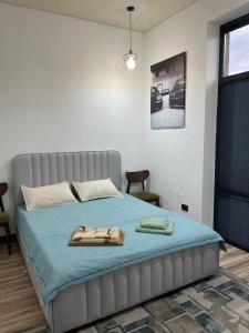 a bedroom with a bed with a blue blanket at Alpha White in Koshkolʼ