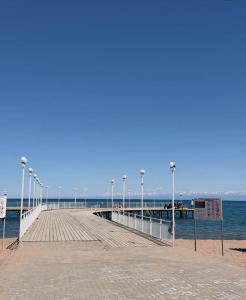 a pier with lights on it next to the water at Alpha White in Koshkolʼ