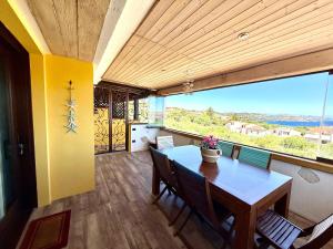 a dining room with a table and a large window at Attico Stella Maris in Palau