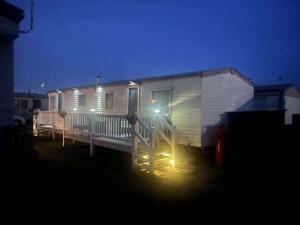 a large white trailer with a porch at night at Ingoldmells holiday in Ingoldmells +5 photos