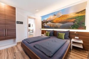 a bedroom with a large painting on the wall at Apartment Zielspitz in Parcines