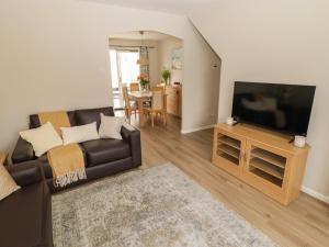 a living room with a couch and a flat screen tv at 7 Cwrt Y Cadno in Llantwit Major