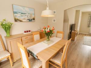 a dining room and living room with a wooden table and chairs at 7 Cwrt Y Cadno in Llantwit Major